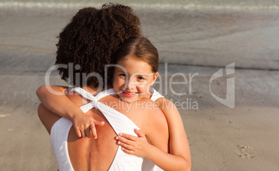 Daughter hugging her mother on the beach