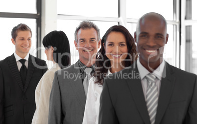 smiling Business man looking at camera with group in background