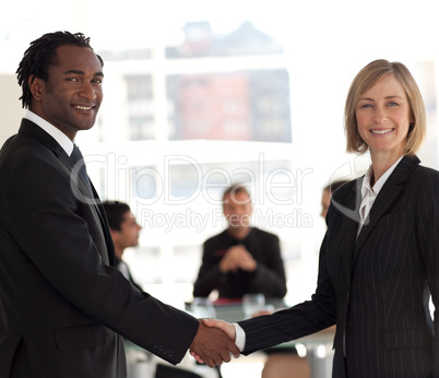 Business handshake in front of workgroup