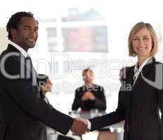 Business handshake in front of workgroup