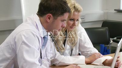 Arzt und Ärztin im Gespräch am Laptop