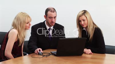 Zwei Frauen und ein Mann am Laptop