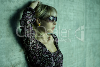 young blonde with sunglasses and one hand in her hair