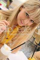 young blond woman in a cafe with latte macchiato