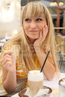 young blonde in a cafe with latte macchiato