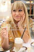 young blonde in a cafe with latte macchiato