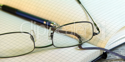 Brille auf Notizbuch