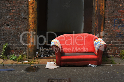 Old abandoned couch in an industrial alley way