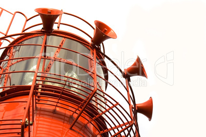Bright red lighthouse with fog horns on white background