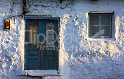 Very old whitewashed Turkish village house with blue wooden door