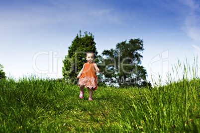 Baby girl running through the park