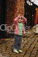 Young black baby girl playing on cobble stoned alley