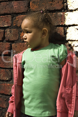Young black baby girl playing in an alley