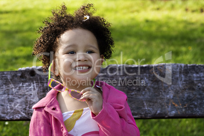 Young black baby girl with glasses smiling