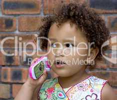 Young black baby girl talking on a toy cell phone