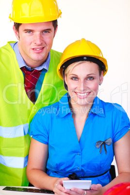 Mann und Frau mit Schutzhelm im Büro