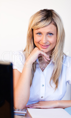 Junge, blonde Frau sitzt am Schreibtisch