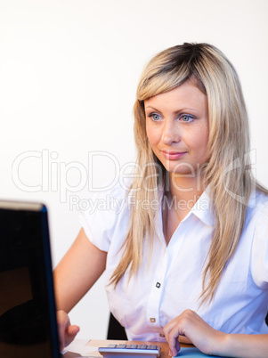 Junge, blonde Frau sitzt am Schreibtisch