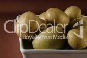 Kartoffeln in Schale auf braunem HG