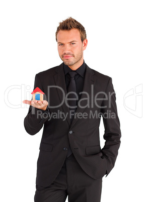 Serious businessman holding house