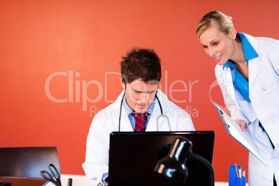 Doctors working with a laptop in office