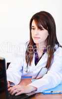 Brunette doctor working with a laptop in hospital