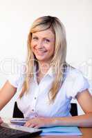 Businesswoman using a laptop and smiling at the camera