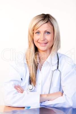 Blonde doctor sitting in an office and smiling at the camera