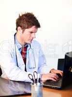 Thoughtful  young doctor working on a computer