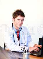 Smiling young doctor working on a computer