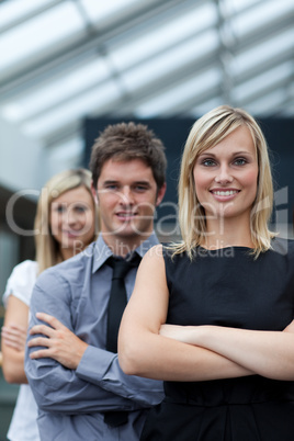 Beautiful businesswoman leading her team with folded arms