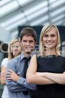 Beautiful businesswoman leading her team with folded arms