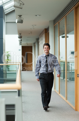 Handsome businessman walking through a corridor