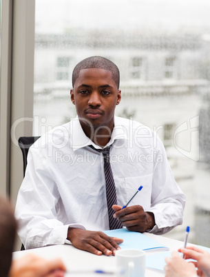 Afro-American businessman writing in an office