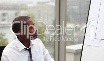 Afro-American businessman looking at a whiteboard