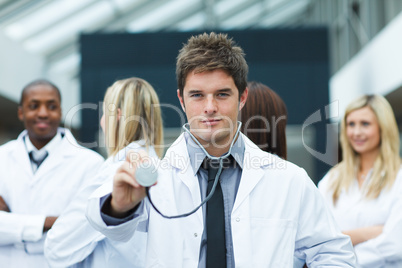 Handsome young doctor in front of his team