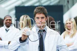 Handsome young doctor in front of his team