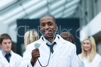 Ethnic doctor with his team in the background