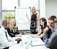 Attractive businesswoman giving a presentation smiling at the ca