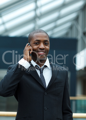 Ethnic businessman on phone and smiling at the camera