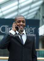 Ethnic businessman on phone and smiling at the camera