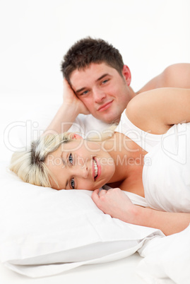 Smiling young couple in bed
