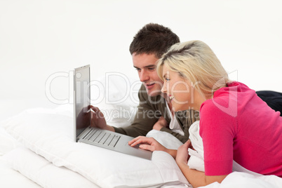 Girl using a latop in bed with her boyfriend