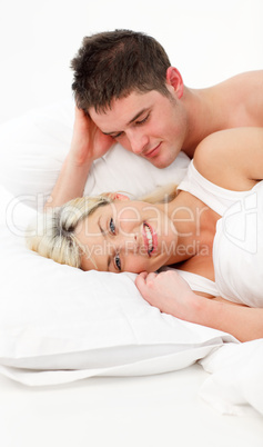 Happy girl with her boyfriend lying in bed
