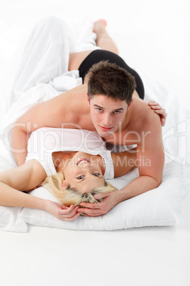 Couple in love in bed looking at the camera