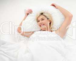 Happy young woman relaxing in bed