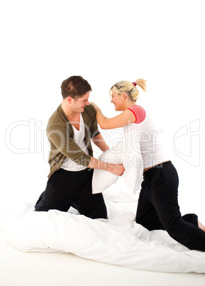 Couple having fighting in bed with pillows