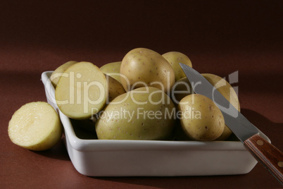 Kartoffeln in Schale auf braunem HG