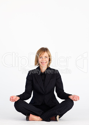 Businesswoman meditating on the floor and smiling at the camera