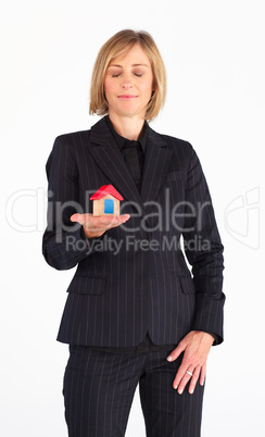 Confident businesswoman holding a house